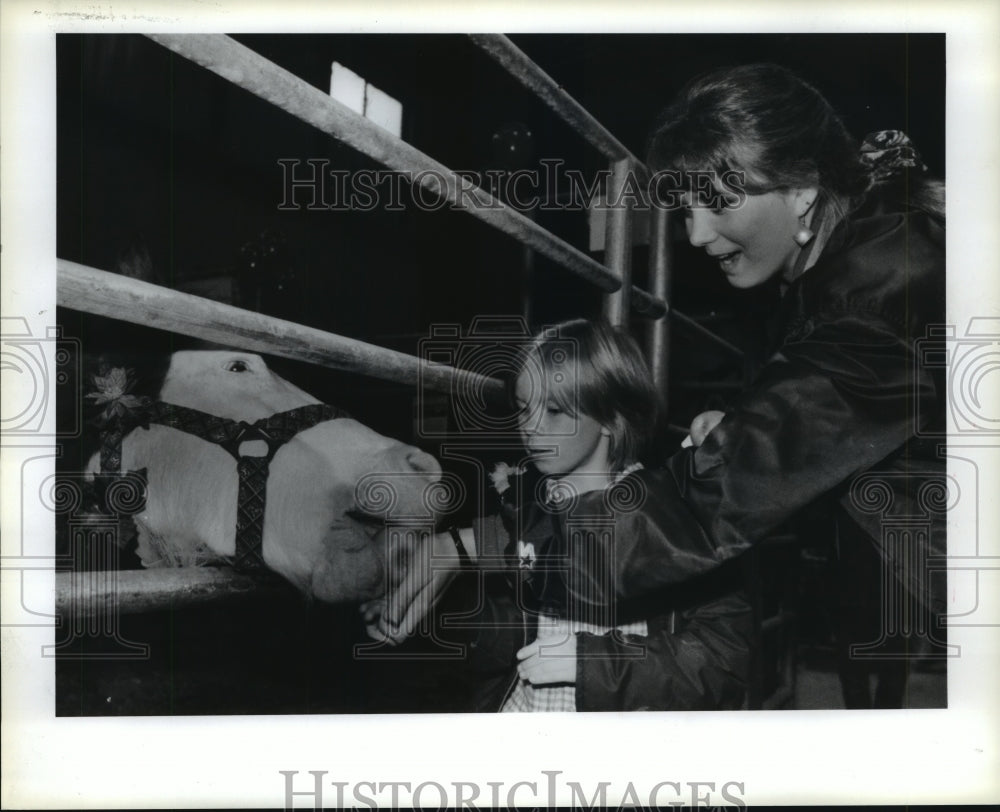 1988 Animal Rescue League's Julie Crowe & child feel pony in Houston - Historic Images