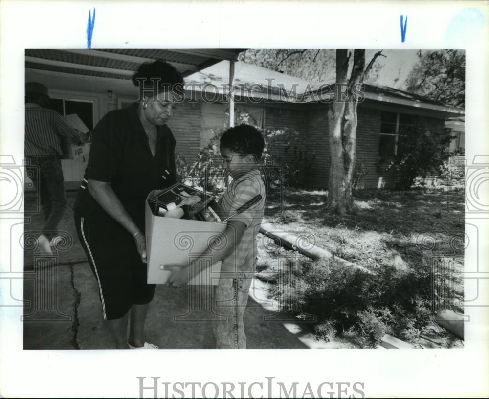 1990 Trovon Robinson helps Gloria Jones move into Houston home - Historic Images