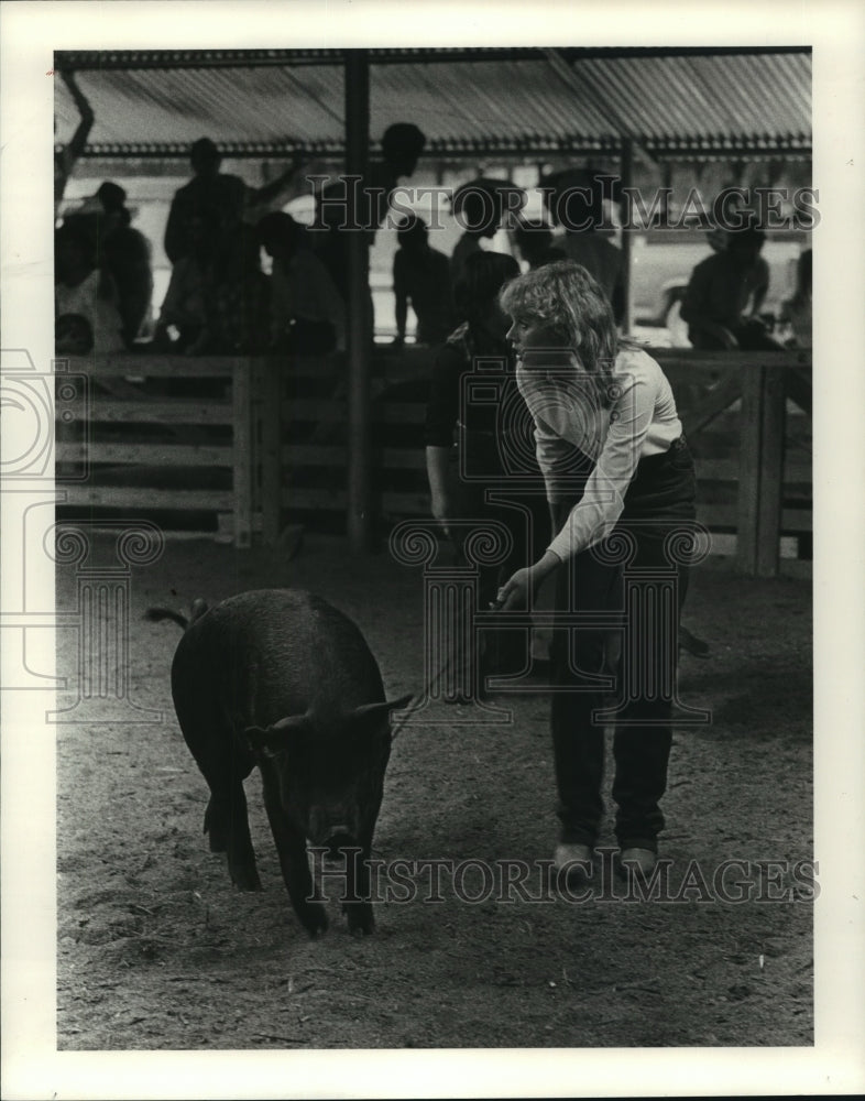 1983 Lynette Hakamer with 1st place hog in show ring in Texas - Historic Images