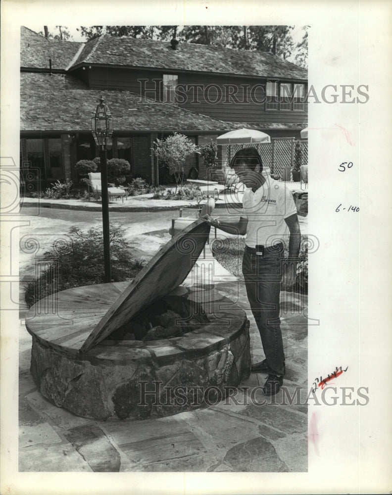 1984 Man stands beside fire pit oustide California home - Historic Images