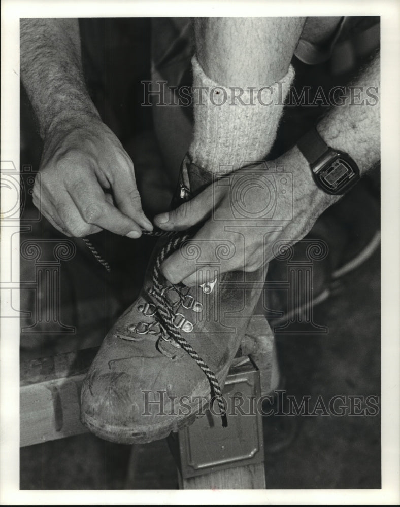 1983 Man ties hiking boot - Historic Images