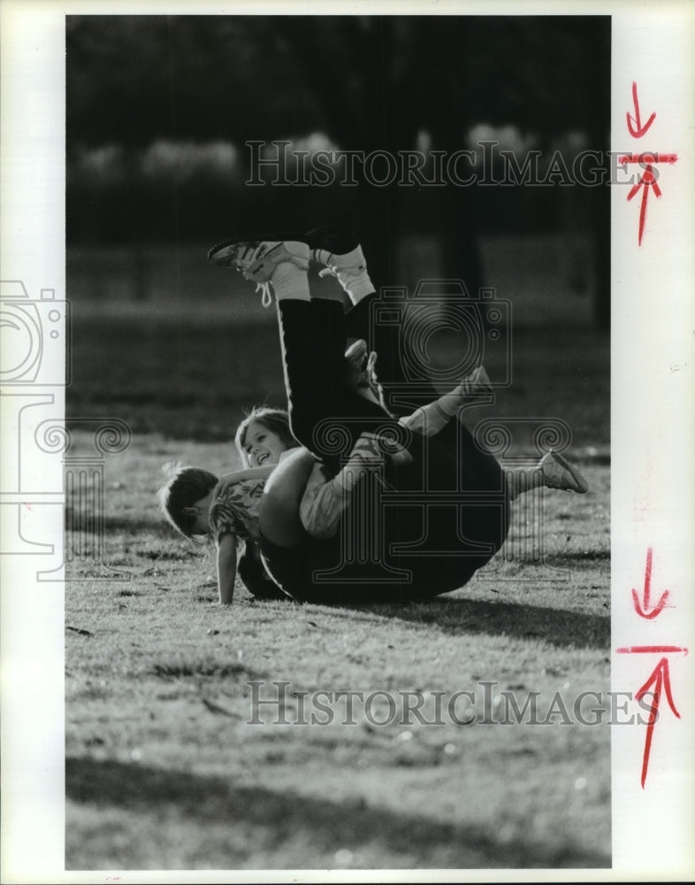 1989 Robert Donovan plays with his children in Hermann Park, Houston - Historic Images