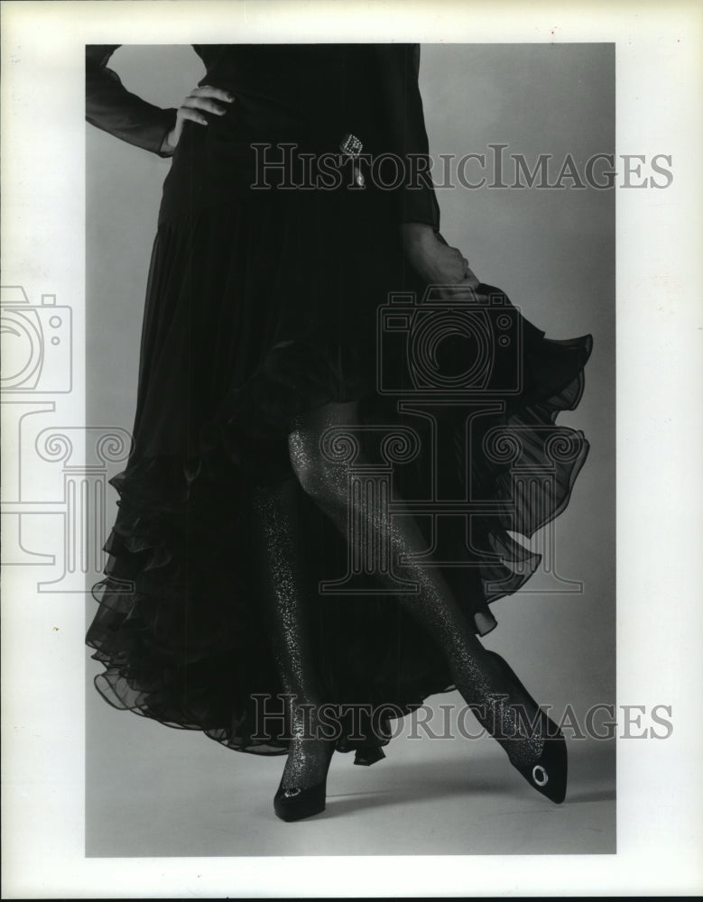 1987 Model with gold-speckled hose, black pumps &amp; black chiffon gown - Historic Images