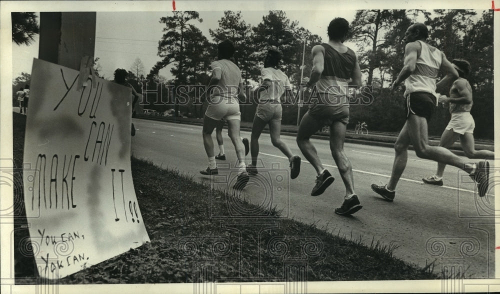 1981 Houston Marathon runners pass encouraging sign - Historic Images