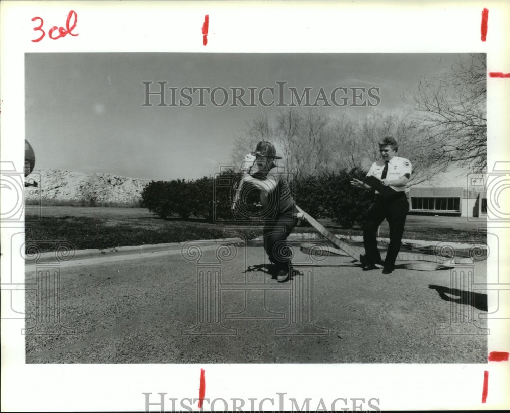 1987 Houston Fireman David Dean hauls hose in standards test - Historic Images