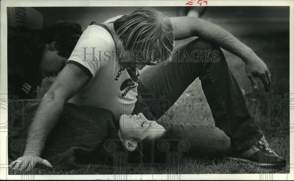 1980 Houston Marathon runner lies on ground with blanket, and friend - Historic Images