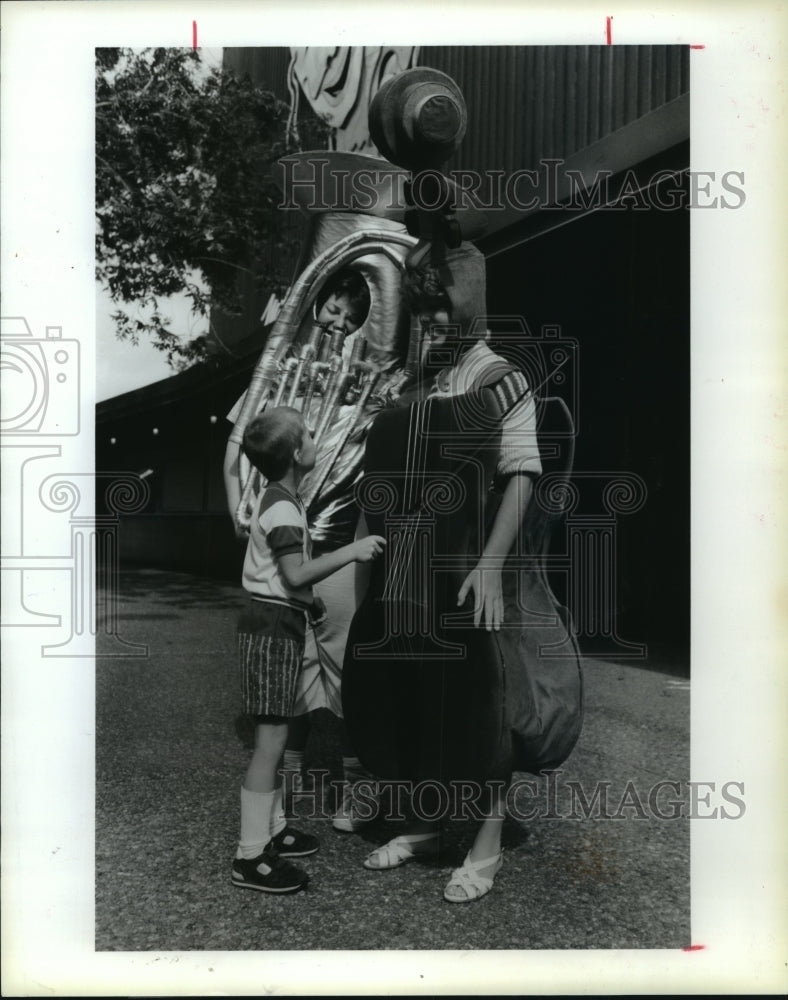 1987 Jimmy Young sees costumed instruments at Houston Symphony event - Historic Images