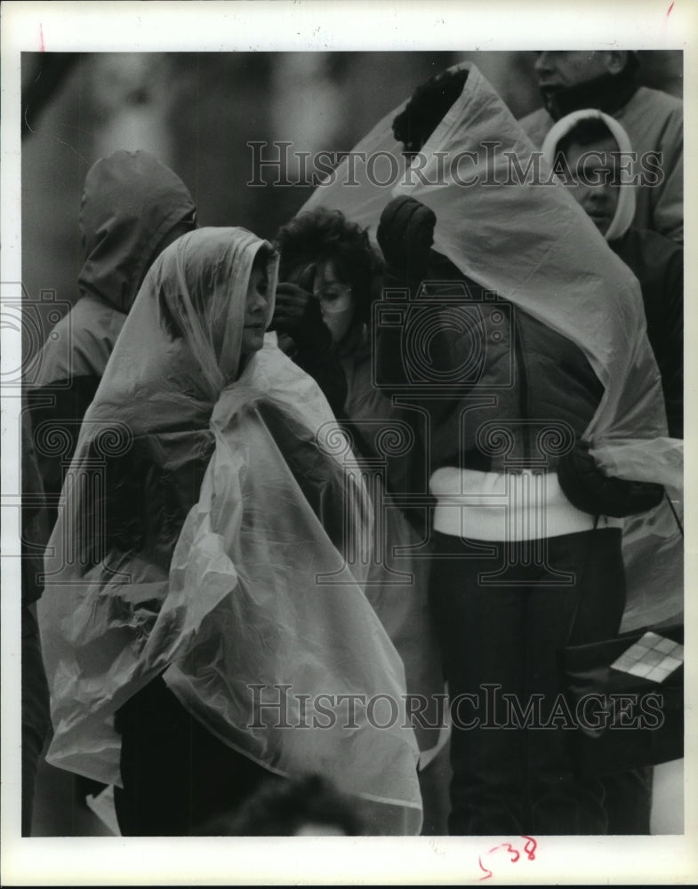 1986 Houston Marathon spectators under plastic bags in the cold wind - Historic Images