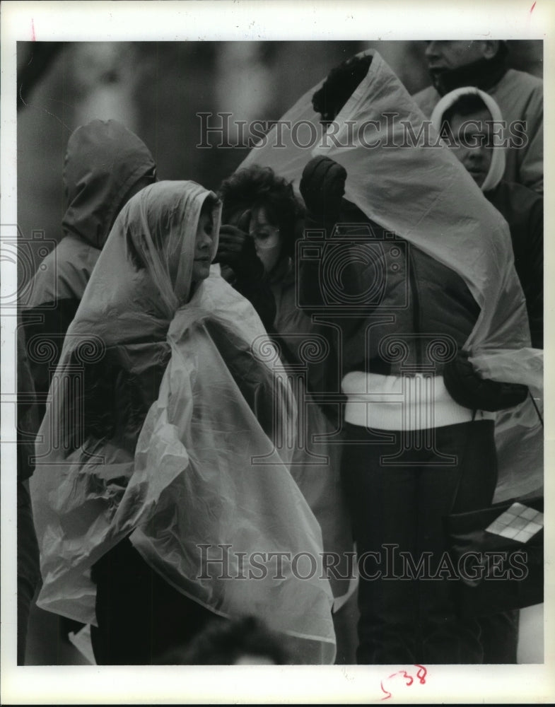 1986 Houston Marathon spectators under plastic bags in the cold wind - Historic Images