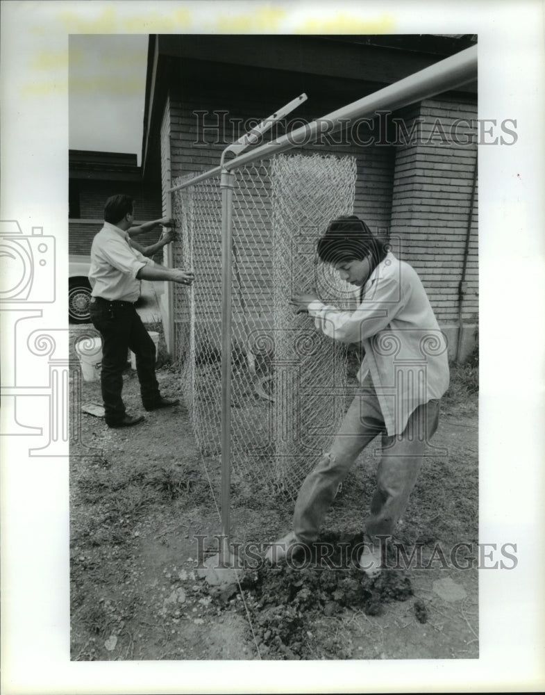 1991 Workers put up fence at Houston Police Magnolia Park Substation - Historic Images