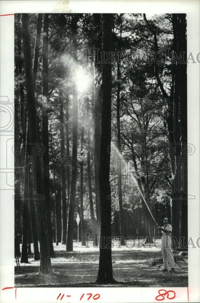 1982 Houston Parks Department Ray Werner sprays insecticide in park - Historic Images