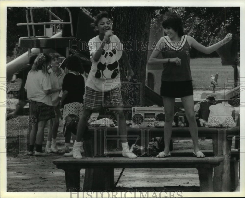 1986 Denise Miller &amp; Deana DeLeon dance on bench at Houston park - Historic Images