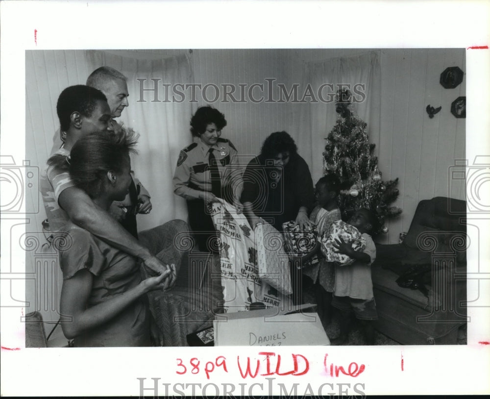 1990 Houston police give family presents as part of Comida campaign - Historic Images