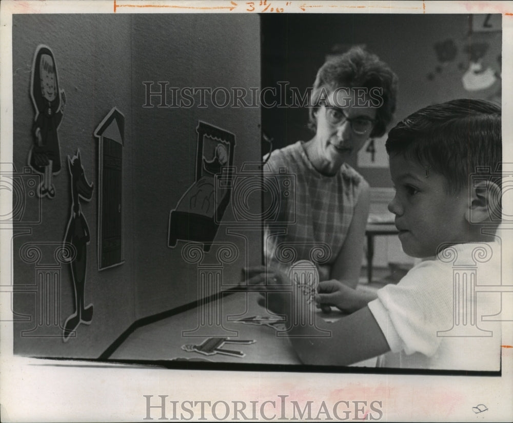 1969 Jeff Monroy plays story board with Mrs. E. B. Herrick - Historic Images