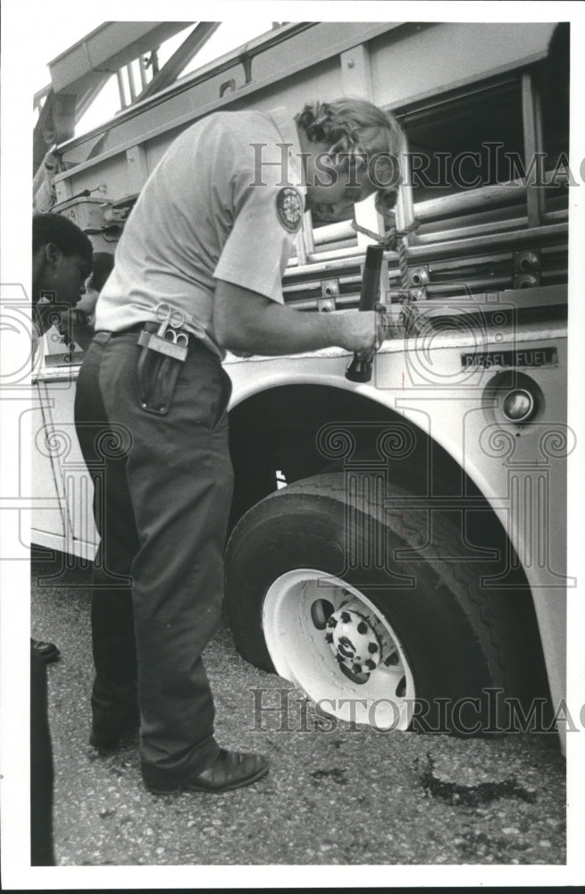 1982 Houston fireman examine truck that fell in pavement hold - Historic Images