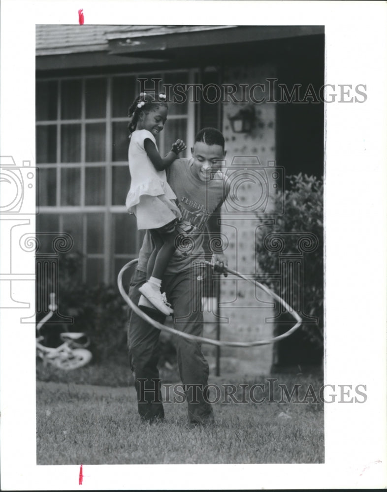 1989 Eric Brown and niece Angel Doby hula-hoop in Houston front yard - Historic Images