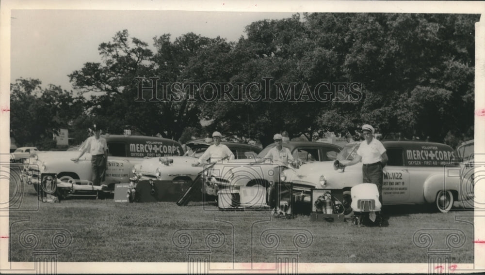 1955 Houston's volunteer Mercy Corps stand next to vehicles - Historic Images