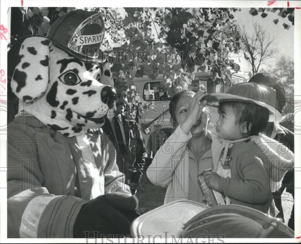 1981 Woman and baby greeted by Houston Fire Dept. Sparky Fire Dog - Historic Images
