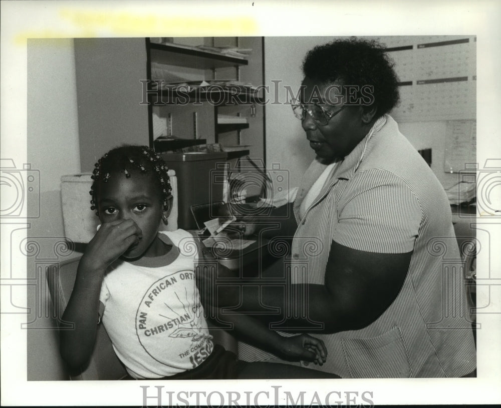 1986 Press Photo Nurse Daniel Simmons give Faida Stokes a shot at Riverside - Historic Images