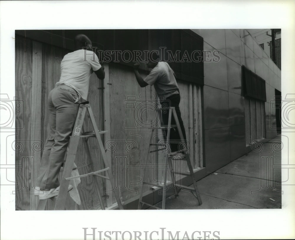 Theo Lloyd and Chad Martin cover windows at Sam's Office on Travis - Historic Images