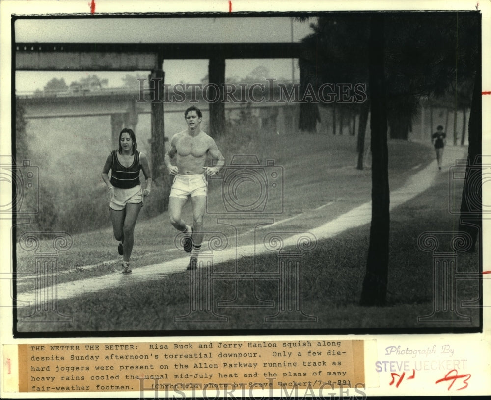 1979 Risa Buck and Jerry Hanlon run along Allen Parkway track - Historic Images