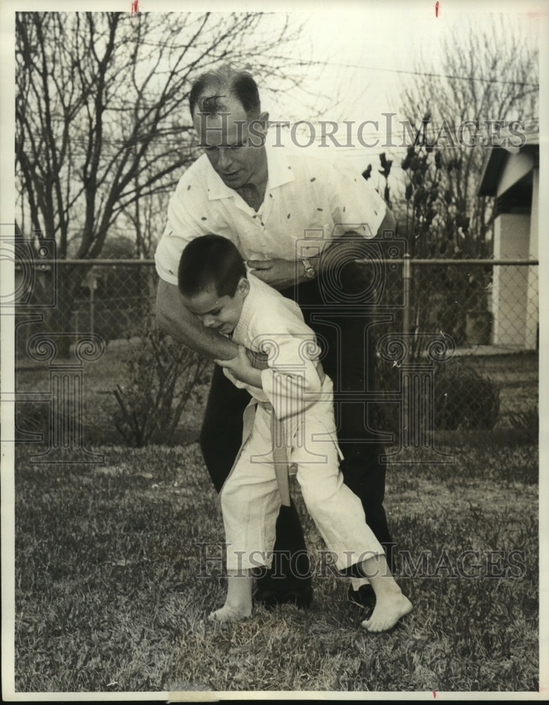 1962 Press Photo Young boy practices Judo on his father at their home-Historic Images