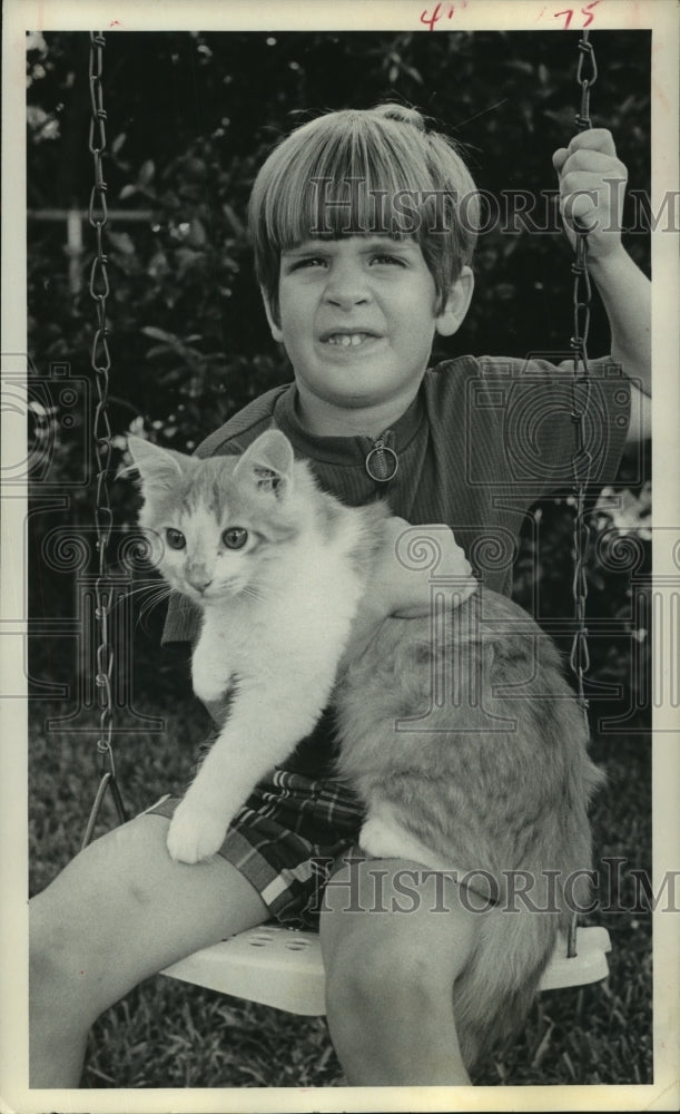 1971 Sean Galloway holds cat while on backyard swing in Houston - Historic Images