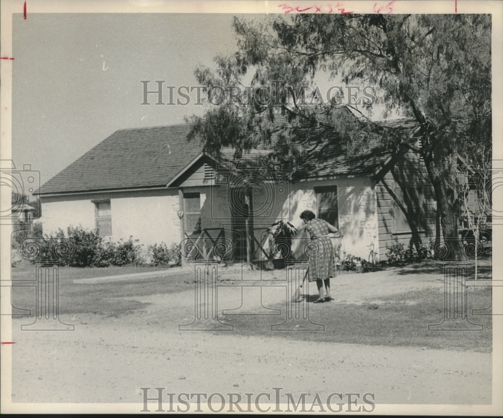 1961 Press Photo Housewife sweeps driveway in Mercedes, Texas - hca41992 - Historic Images