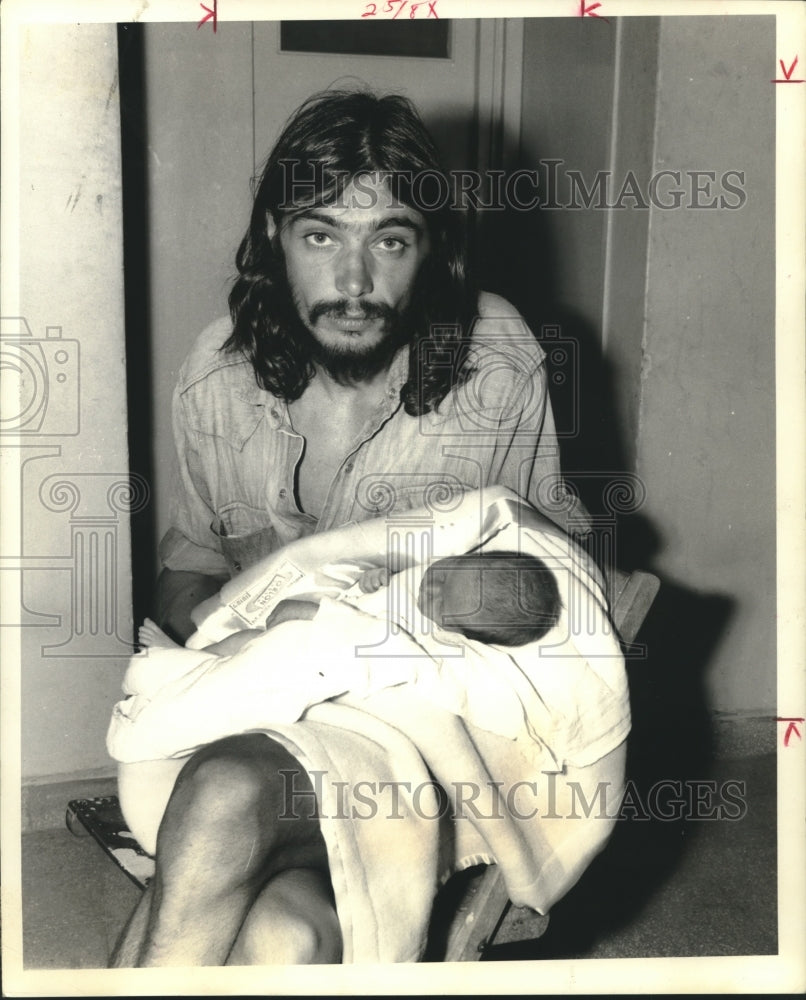 1970 French hippie and mercenary holds baby daughter - Historic Images