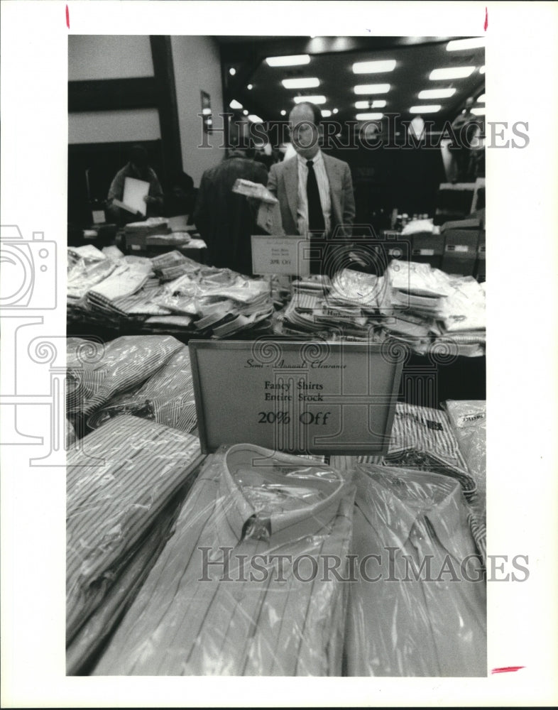 1991 Press Photo Tom Henderson examines shirt sale at Norton Ditto, Houston - Historic Images