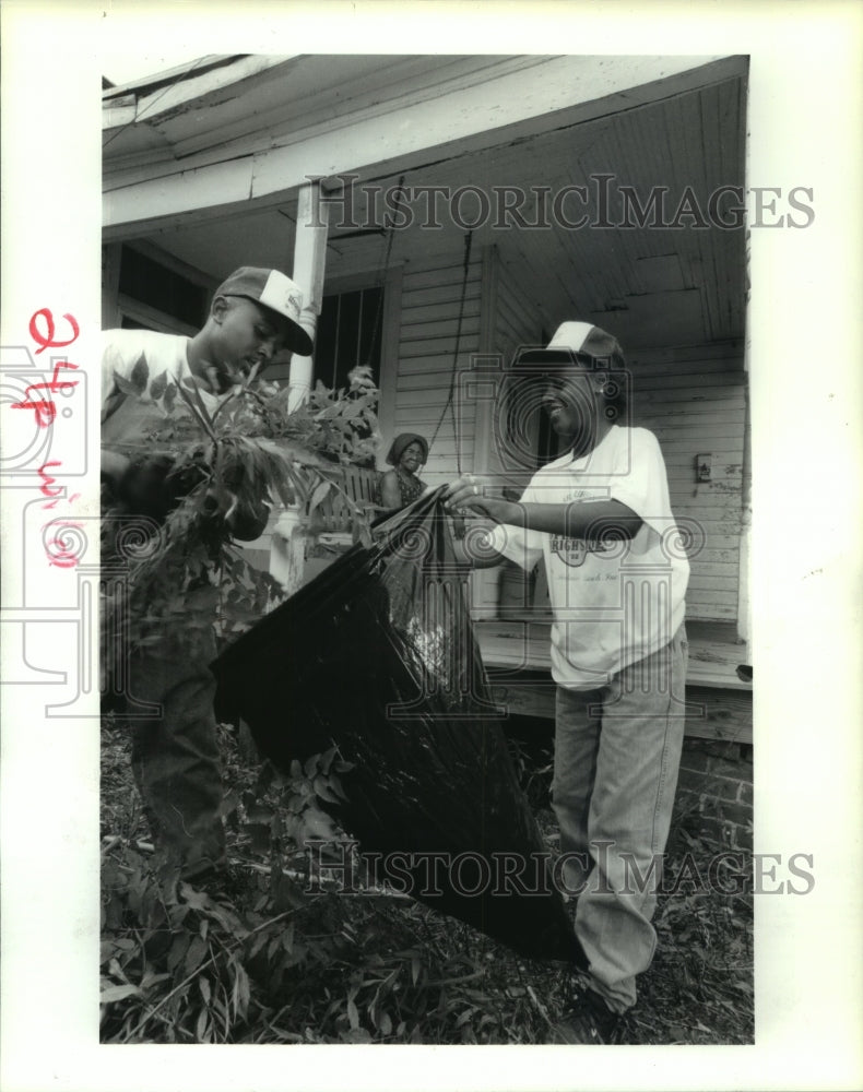 1992 Press Photo Operation Brightside employees clean up yard in Houston - Historic Images