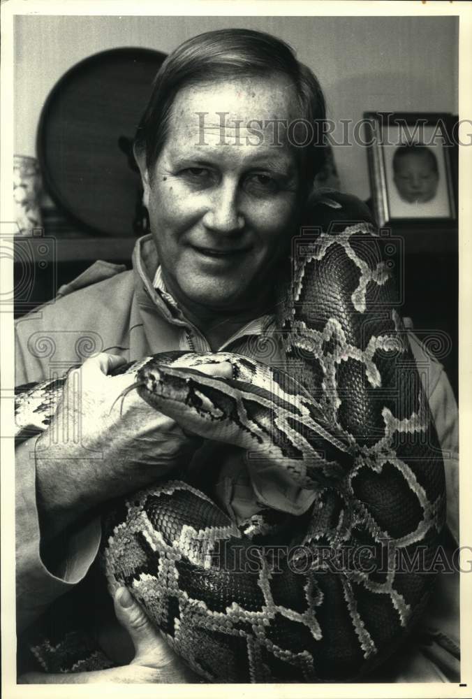 1987 Press Photo Naturalist Jim Fowler holds a 12-foot Burmese Python. - Historic Images