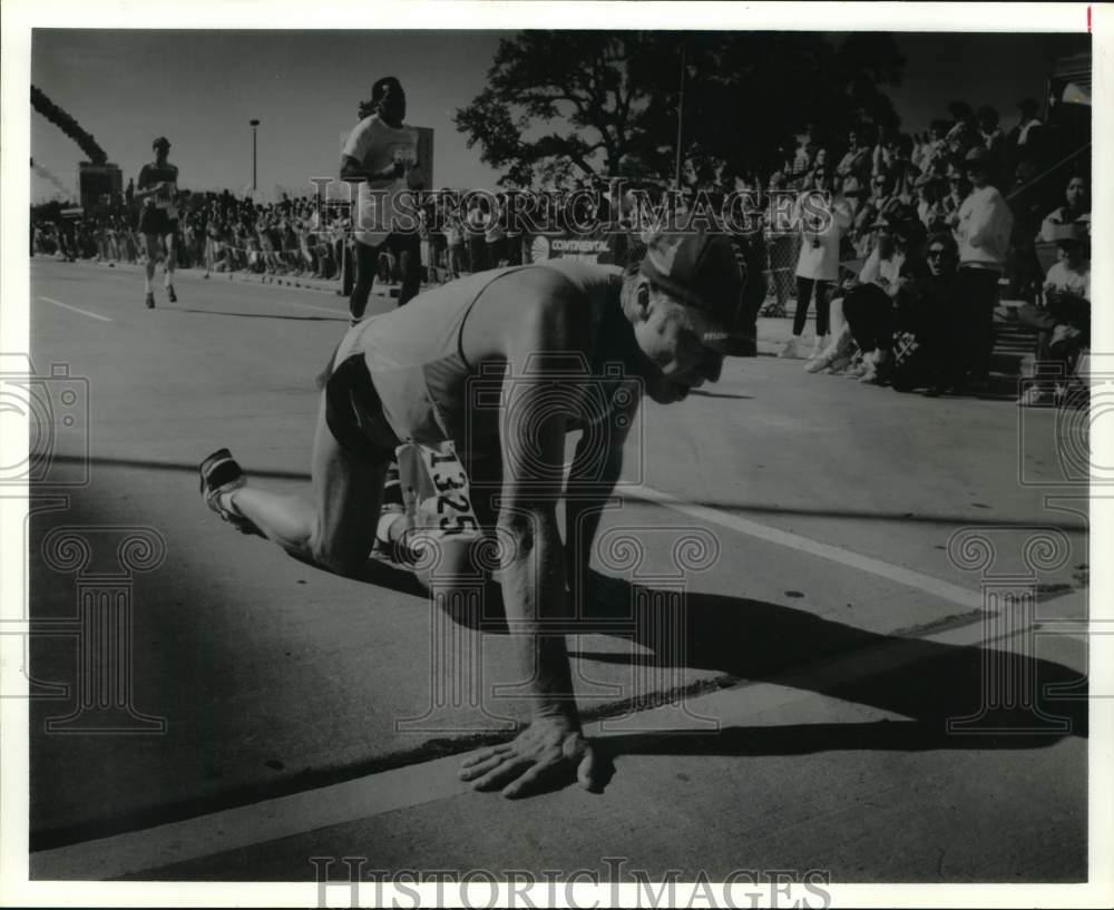 1992 Press Photo Elderly participant crawls over finish line in Houston Marathon - Historic Images