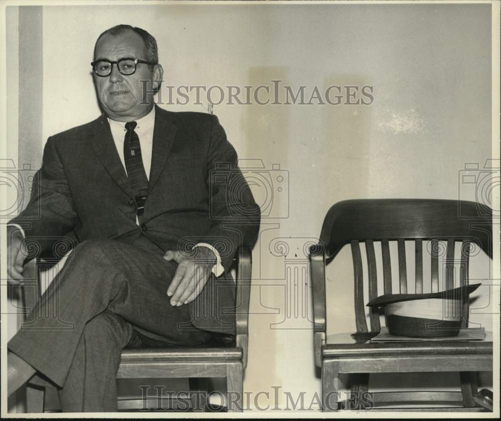 1957 Press Photo Man Sits in Wooden Desk Chair - Historic Images