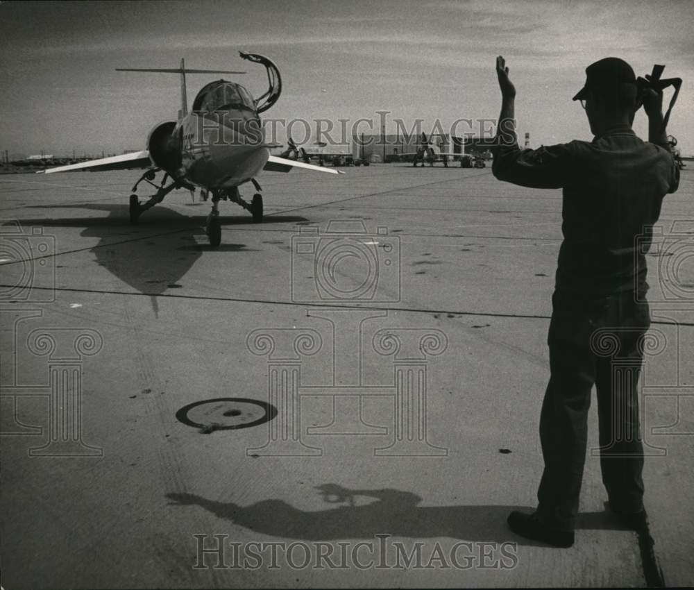 1964 Man directs F104 Starfighter on runway-Historic Images