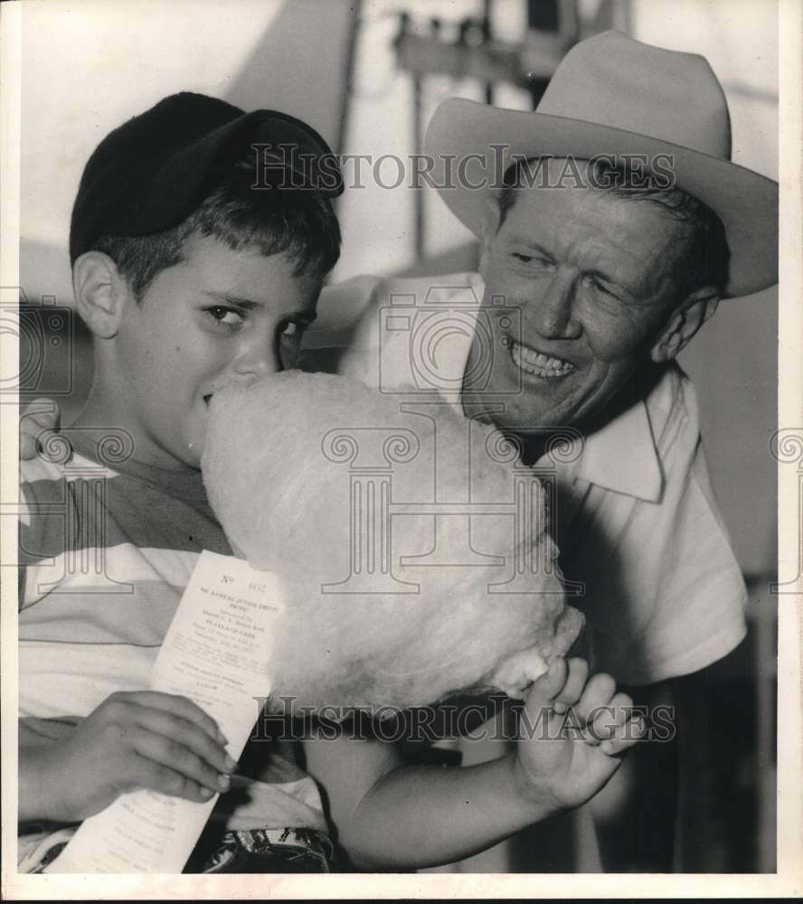 1955 Richard Rainey enjoys cotton candy from Sheriff C.V. Kern - TX-Historic Images