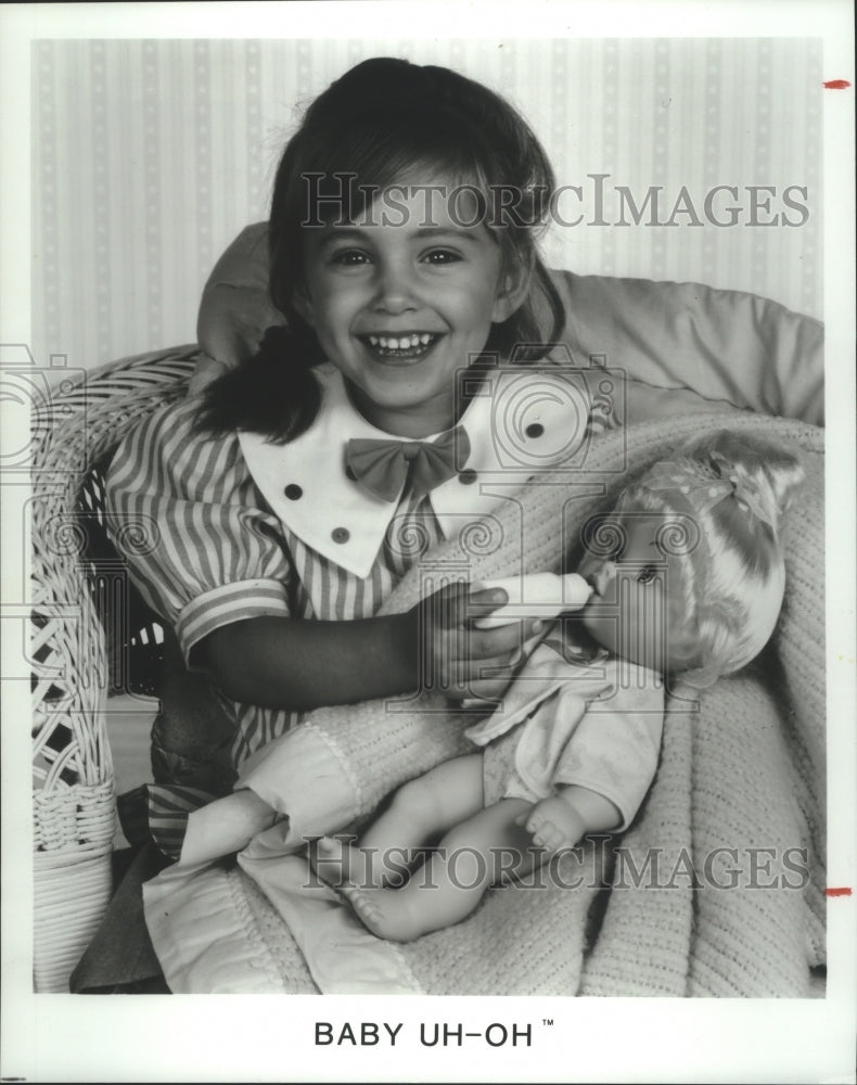 1990 Press Photo Child holding Hasbro's Baby Uh-Oh, a realistic doll.- Historic Images