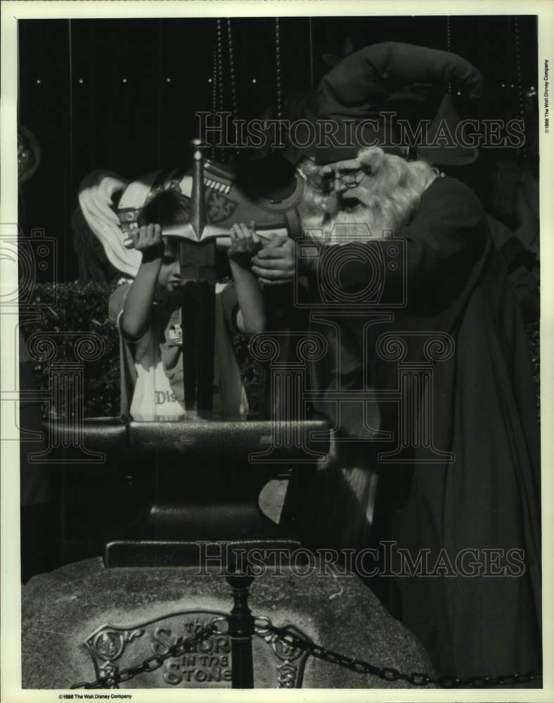 1986 Press Photo Merlin the Magician helps child pull sword from stone- Historic Images