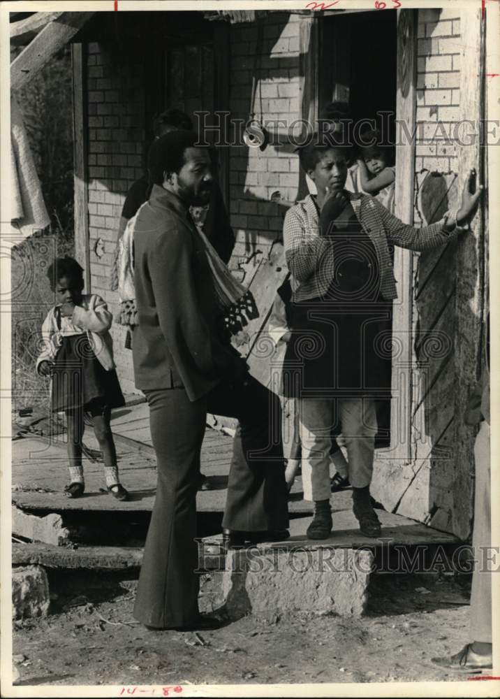 1970 Press Photo Entertainer Jim Brown with child and woman by house. - Historic Images