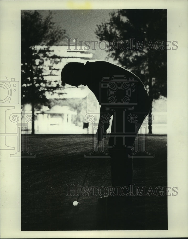 1986 Press Photo Golfer concentrates on putting during Sugar Creek night tourney- Historic Images