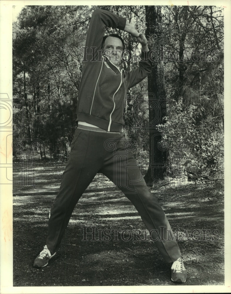 1980 Press Photo Long distance runner Bill Emmerton limbers up before his run. - Historic Images