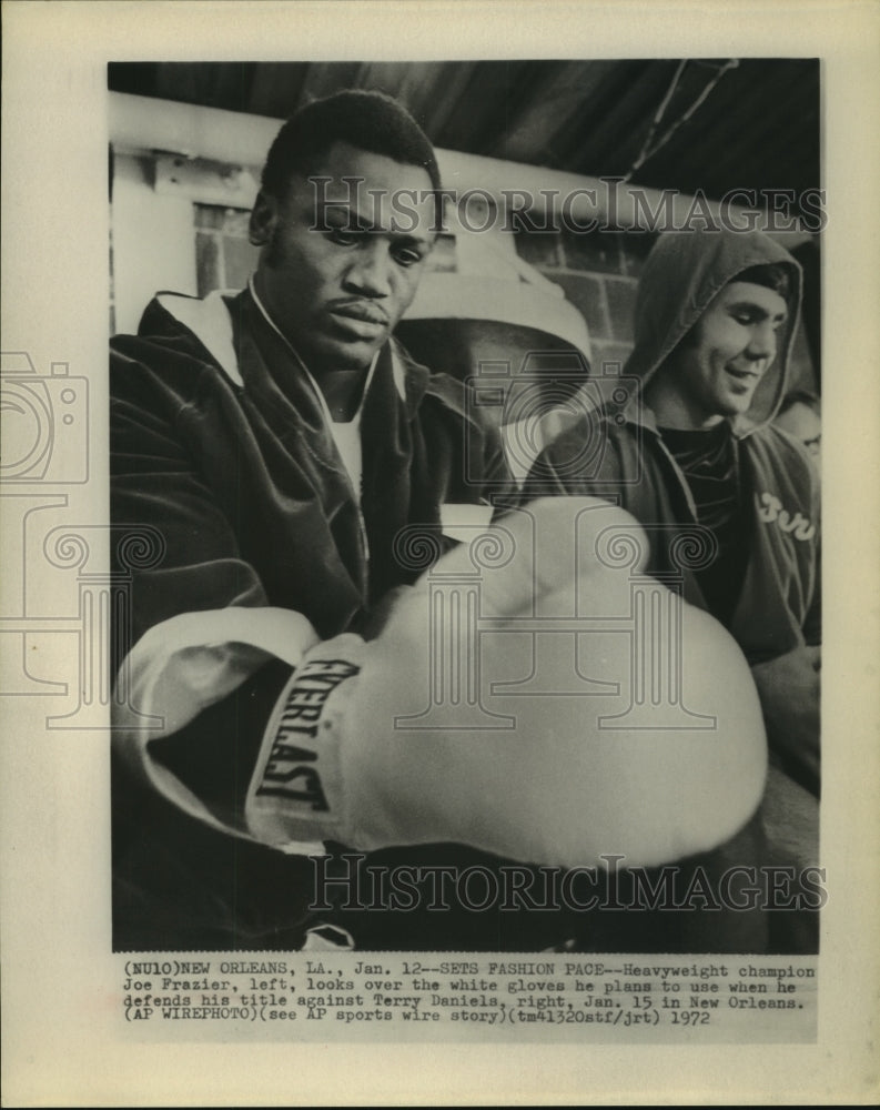 1972 Press Photo Heavyweight champ Joe Frazier inspects gloves for title bout. - Historic Images