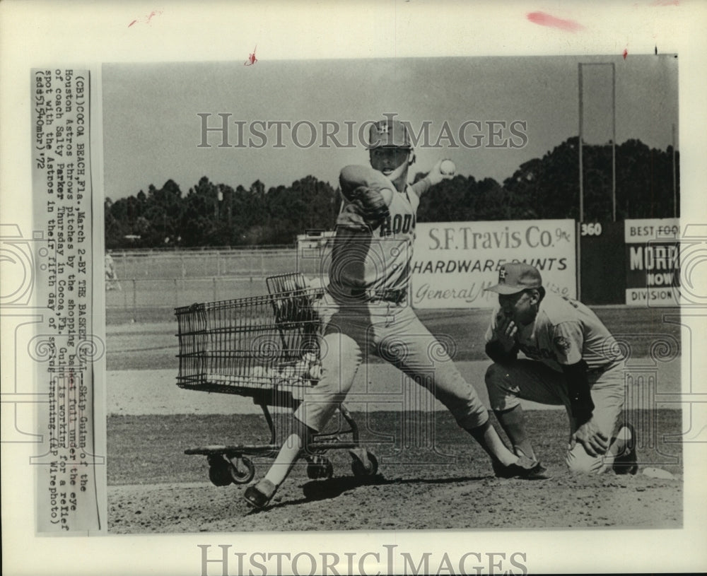 1972 Houston Astro's pitcher Skip Guinn throws while coach watches. - Historic Images