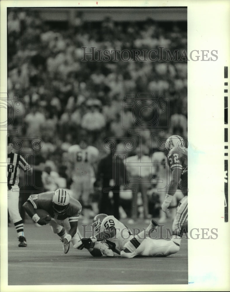 1987 Press Photo Oilers&#39; quarterback Warren Moon tackled by Browns defender.- Historic Images