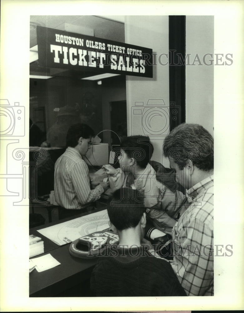 1987 Press Photo Johnny Aldape and sons get tickets at Oilers headquarters - Historic Images