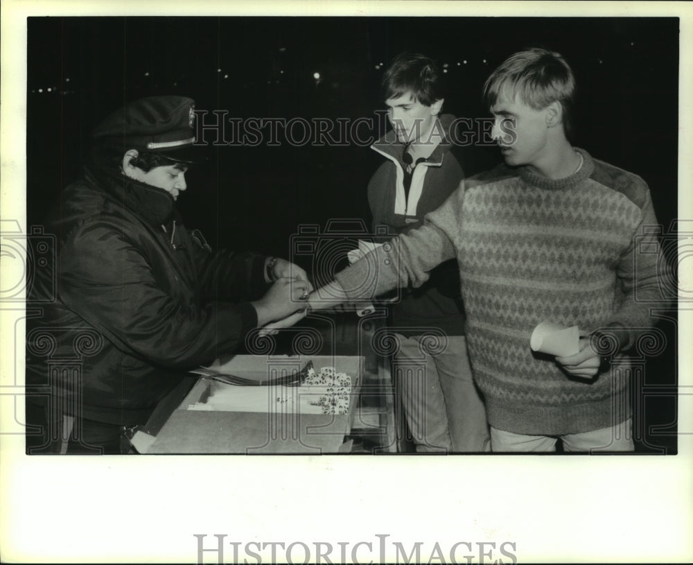 1987 Press Photo Astrodome security guard gives wristbands to ticket buyers. - Historic Images