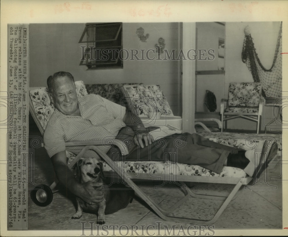 1968 Press Photo Harold "Red" Grange, relaxes at home with dog Rusty. - Historic Images