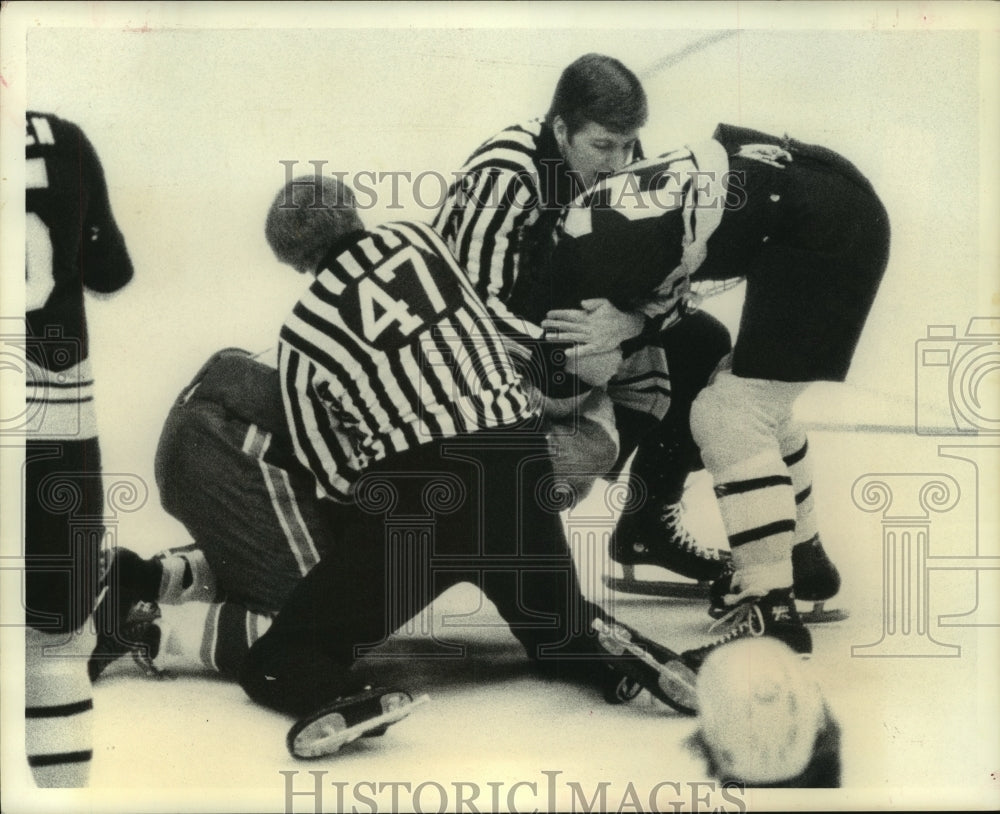 1976 Press Photo Referees break up a fight on the ice during Houston Aeros game.- Historic Images