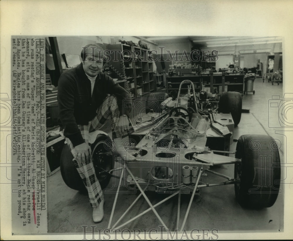 1974 Press Photo Parnelli Jones sits on wheel in his Los Angeles racing shop. - Historic Images