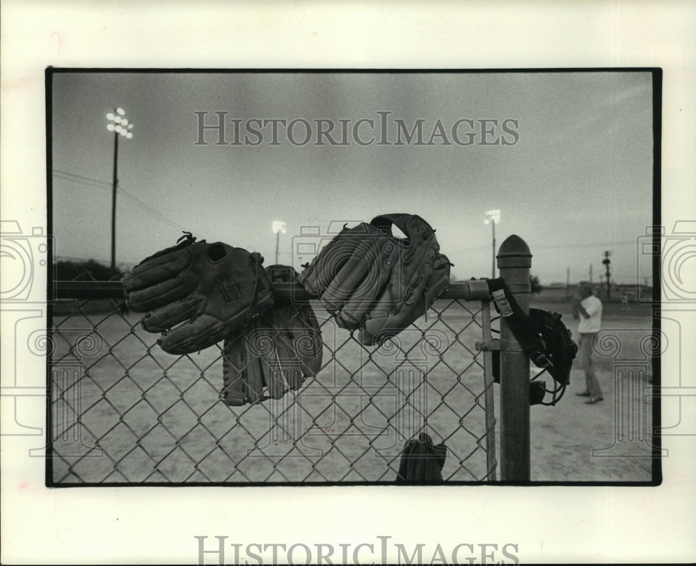 1974 Ball gloves adorn fence at Houston Chronicle Softball Tourney. - Historic Images